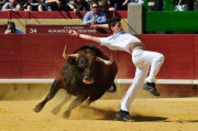 Un especialista ejecutando un recorte frente a un voluminoso toro.